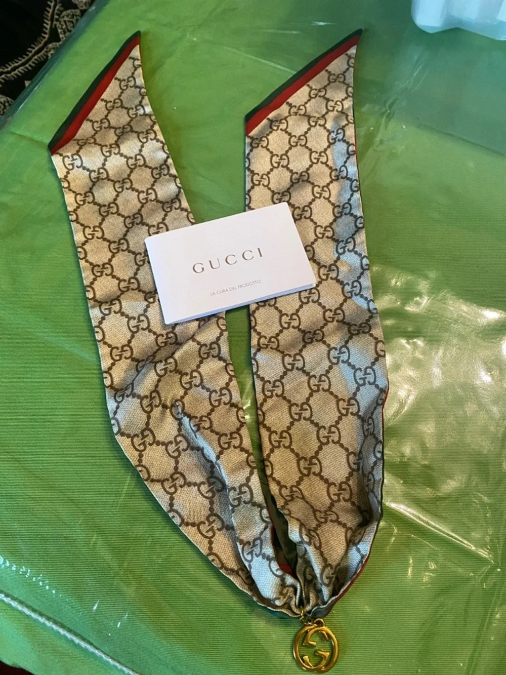 Gucci beige brown GG monogram silk twilly with red trim and gold charm with box